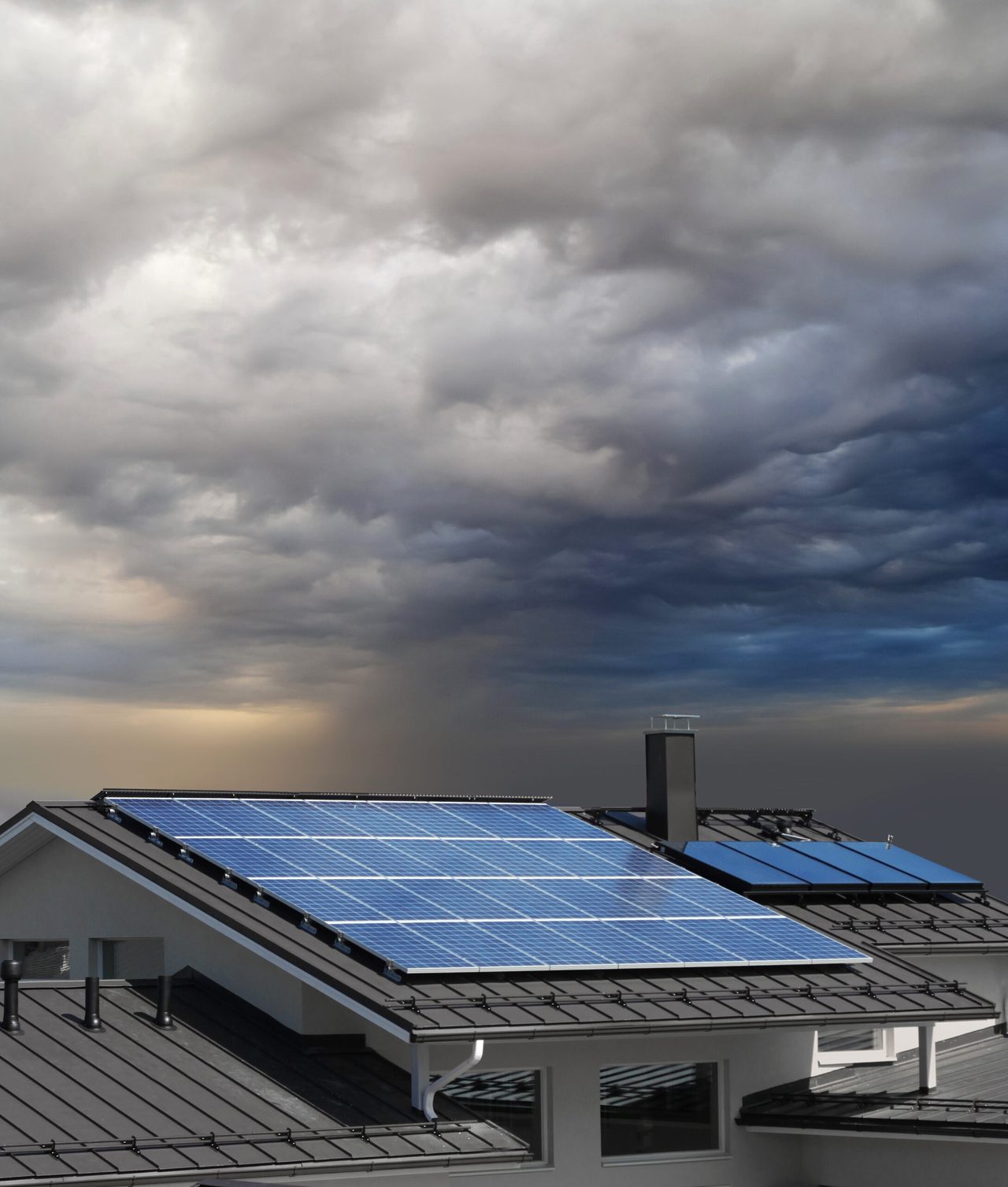 Solar panels on the roof of a house beneath a cloudy sky